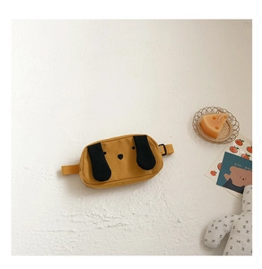 Detail view of yellow canvas puppy waist bag for boys with 3D ears and embroidery