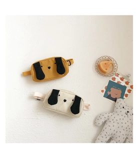 Detail of canvas dog-shaped kids chest bags in mustard yellow and off-white colors