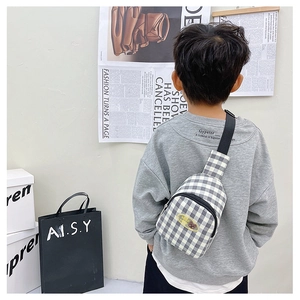 Détail du sac de poitrine enfant à carreaux avec patch ours jaune et sangle réglable