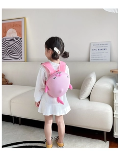 Pink cartoon shark hard shell backpack for kids worn by a toddler in a bright room