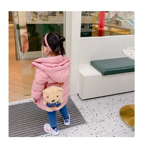 Détail de doudoune rose pour enfant avec sac à dos ours en peluche 3D intégré au dos