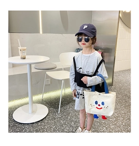 Detail of cute kid's canvas lunch bag with bright smiley face and plush doll legs