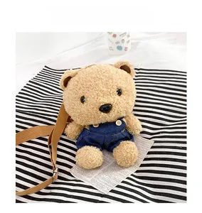 Détail du sac bandoulière en peluche ourson avec salopette en jean et sangle ajustable