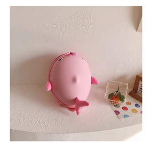 Detail of pink cartoon shark backpack with hardshell body and soft plush fins