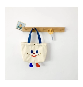 Detail of cute canvas kids handbag with 3D legs and cartoon embroidery on wood hook