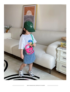 Détail du mini sac bandoulière rose avec chaîne en résine verte et bouton contrasté
