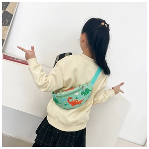 Détail du sac bandoulière enfant vert menthe avec imprimés dinosaures et zip métallique