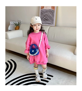Détail de la robe en tricot rose à manches longues et du mini sac à bandoulière bleu