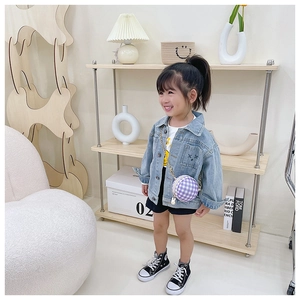 Fashionable young girl wearing denim jacket and a purple checkered round mini crossbody bag