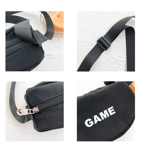 Détail du sac en toile noire montrant la fermeture éclair cœur et la sangle réglable