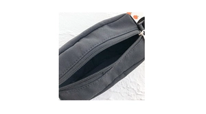 Vue détaillée du sac à bandoulière en toile noire avec fermeture éclair et doublure