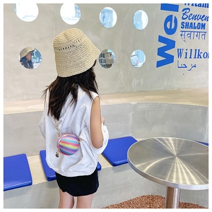 Close-up of a stylish kids' rainbow sphere crossbody bag paired with a straw sun hat