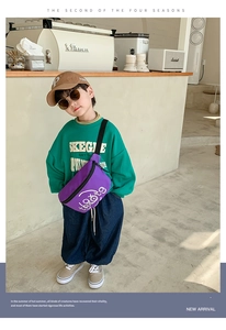 Detail of purple canvas kids chest bag with adjustable strap and text logo in a cafe setting