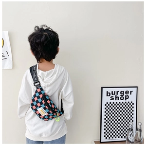 Detail of kids checkerboard crossbody bag with pink and blue pattern and yellow puller