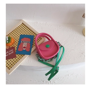 Détail du mini sac bandoulière rose et vert contrasté avec décoration de chaîne chic