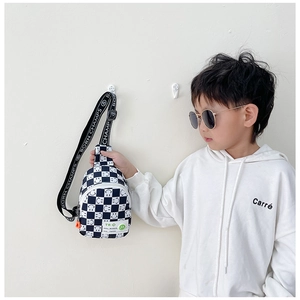 Détail du sac bandoulière enfant à damier avec motif smiley et sangle à logo