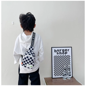 Détail du sac de poitrine à damier pour enfants avec sangle réglable et smiley
