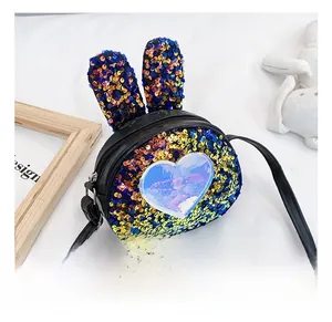 Detail of black sequined kids crossbody bag with cute rabbit ears and blue heart patch