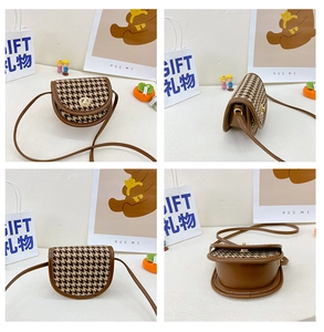 Macro view of plaid saddle bag showing brown trim detail and golden twist lock closure