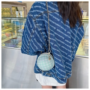 Detail of mint green and white checkered round crossbody bag with golden chain strap