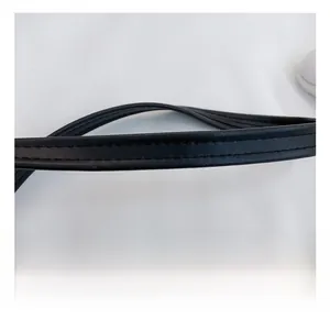 Detail of black faux leather shoulder strap with neat stitching and litchi texture