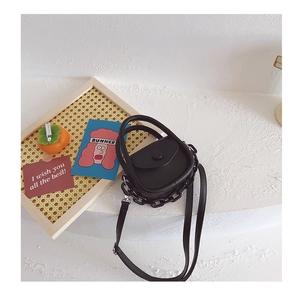 Détail d'un mini sac en cuir PU noir avec chaîne en résine et bandoulière réglable