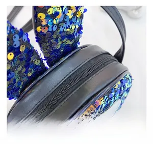 Detail view of smooth zipper closure and blue sequin weave on rabbit ears crossbody bag