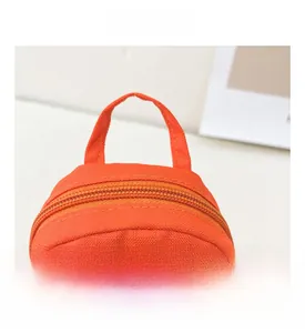 Detail view of the orange canvas mini bag with top handle and secure zipper closure