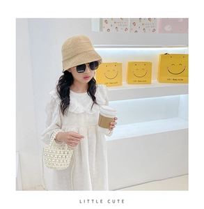 Detail shot of a white beaded handbag with straw hat and lace dress for girls