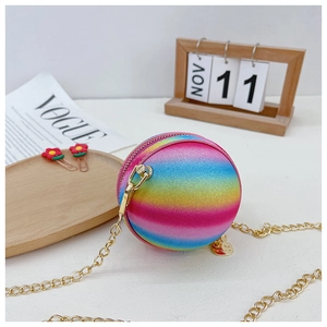 Detailed macro view of vibrant rainbow gradient sphere bag with glittering surface and charm