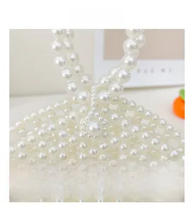 Macro view showing the intricate hand-woven pearl bead structure of the girls' handbag