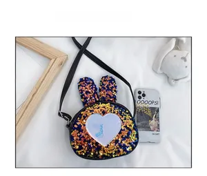 Detail of sequined bunny ear kids crossbody bag with white heart patch and adjustable strap