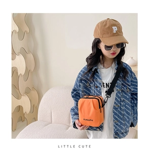 Close-up of bright orange canvas crossbody bag for kids with adjustable black strap