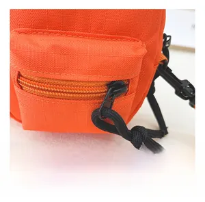 Detailed macro view of orange mini canvas bag with nylon texture and zipper pocket
