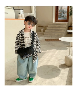 Fashionable boys outfit with checkered shirt, strawberry T-shirt, and black chest bag