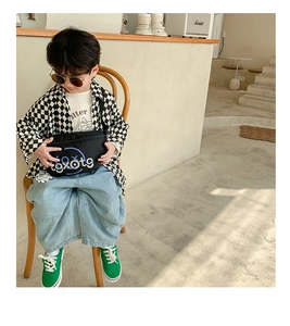 Detail of a boy wearing a stylish black crossbody chest bag with blue graphics