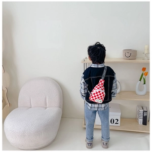 Détail du sac de poitrine enfant à damier rouge et blanc avec sangle lettrée