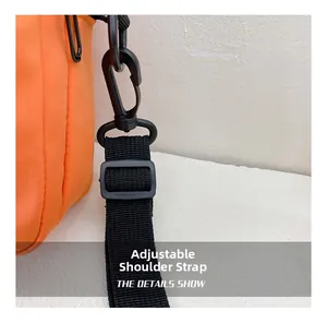 Detail of adjustable black nylon strap and plastic swivel hook on orange canvas bag