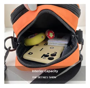 Internal capacity of the orange nylon crossbody bag with dual zipper compartments