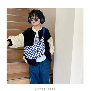 Blue and white checkered kids crossbody bag with adjustable strap shown on model