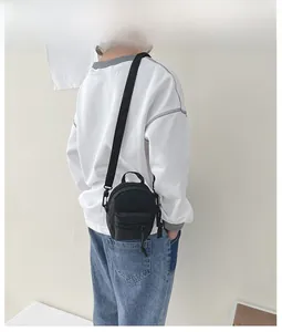 Back view of a mini black canvas crossbody bag with adjustable strap and top handle