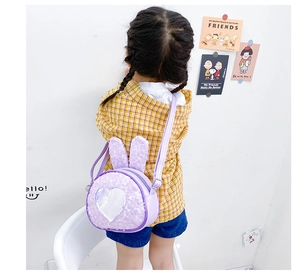 Toddler girl wearing a purple sequin bunny crossbody bag with heart detail