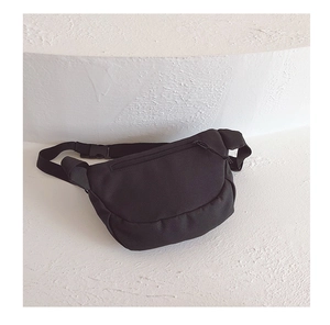 Detail of black nylon boy's chest bag showing durable texture and plastic buckle strap