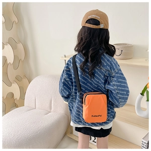 Detail of bright orange nylon kids crossbody bag with adjustable wide black strap