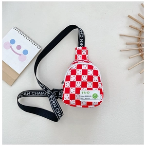 Détail d'un sac de poitrine à carreaux rouges pour enfants avec motif smiley et sangle