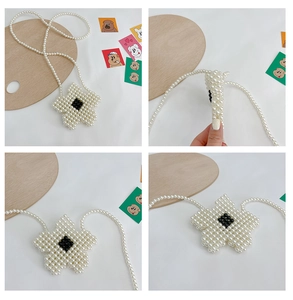 Macro view of handmade white pearl woven flower bag for girls with black pearl accents