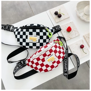 Detail of kids checkerboard chest bags in black and red with branded woven straps