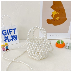 Detail of white handmade pearl beaded bucket bag with elegant woven texture and handle