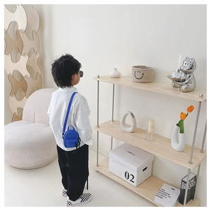 Mini electric blue canvas crossbody bag for kids shown in a minimalist home lifestyle setting