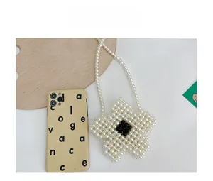 Handmade pearl beaded flower bag for girls with black accent and size reference object